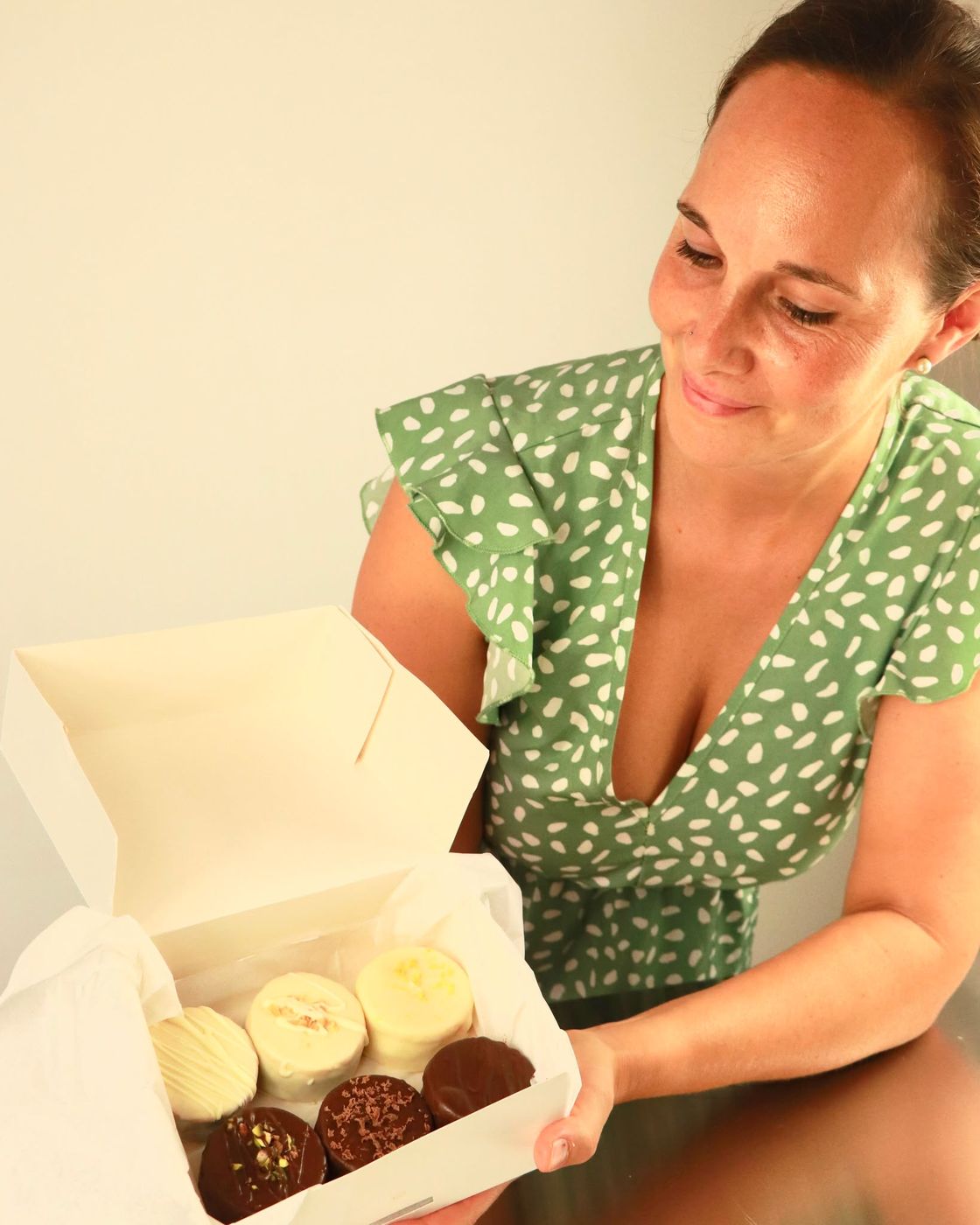 Lizzy, fundadora de Delizzia, con una caja de alfajores